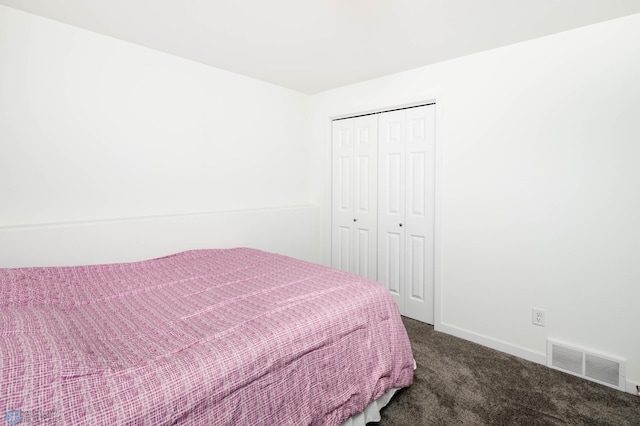 carpeted bedroom featuring baseboards, visible vents, and a closet