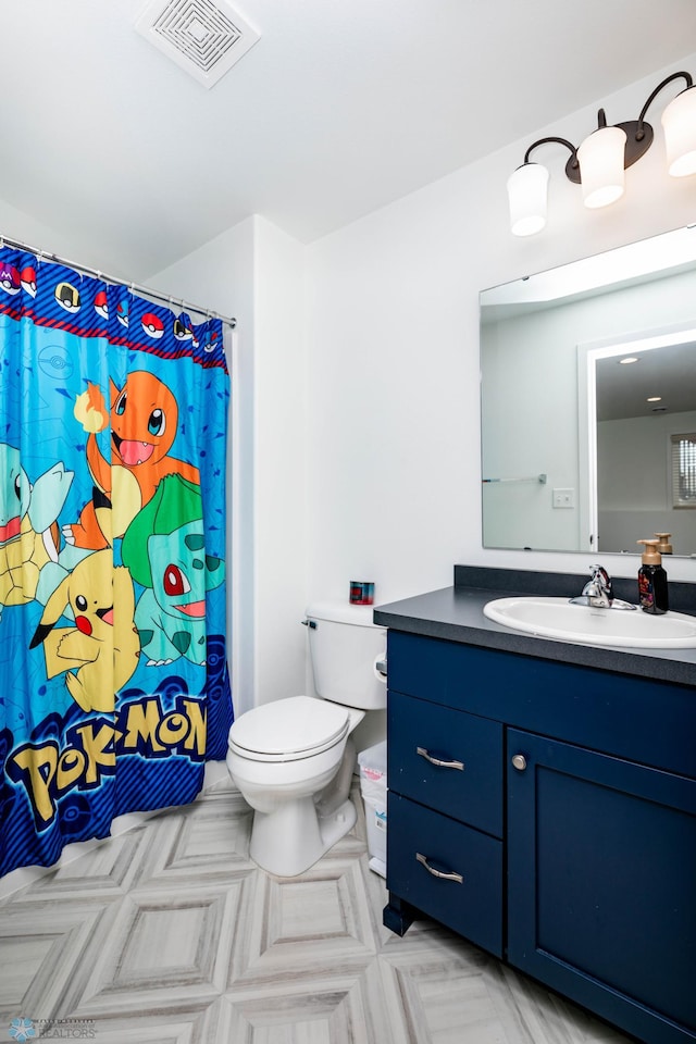 bathroom featuring toilet, vanity, visible vents, and a shower with curtain