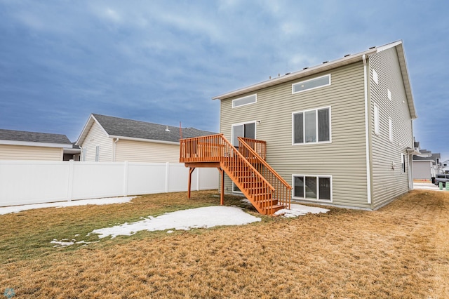 back of house featuring stairs, fence, a lawn, and a wooden deck