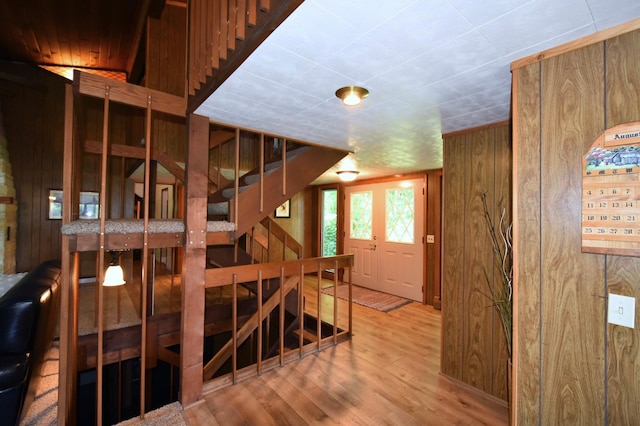 staircase with wooden walls and wood finished floors