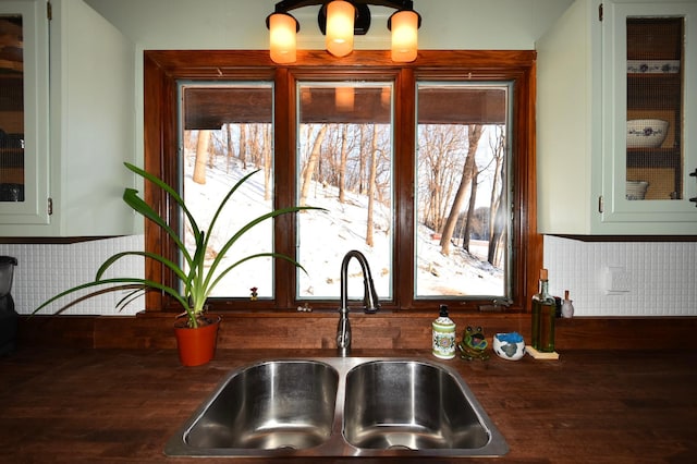 details with dark countertops, a sink, glass insert cabinets, and green cabinetry