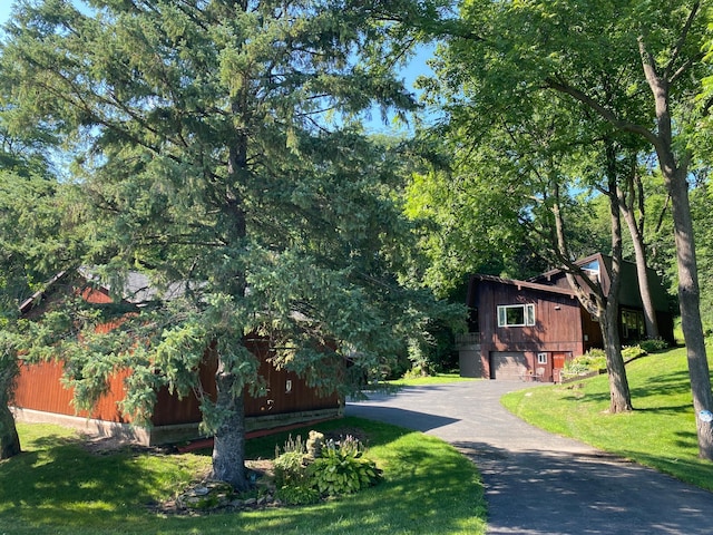 view of front of property featuring a garage, aphalt driveway, and a front yard