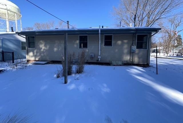 view of snow covered back of property