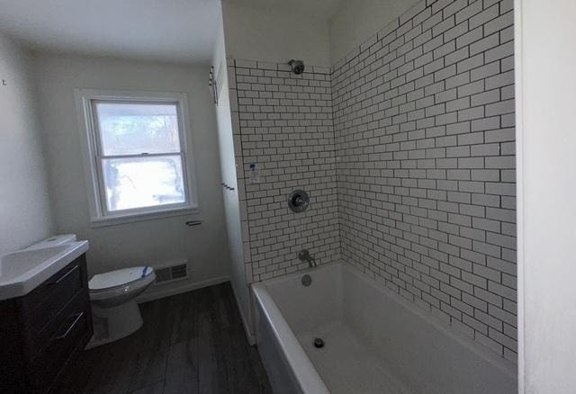 bathroom featuring toilet, wood finished floors, vanity, visible vents, and shower / bathing tub combination