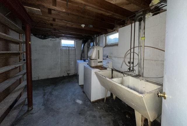 basement with washing machine and dryer and a sink