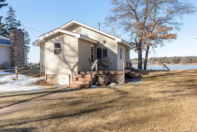 rear view of house featuring a wooden deck, a yard, and fence