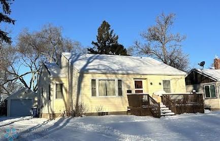 view of front of house with a garage and an outbuilding