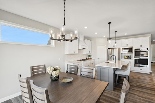 dining space featuring an inviting chandelier, baseboards, dark wood-type flooring, and recessed lighting