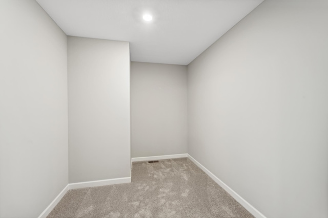 spare room with light carpet and baseboards