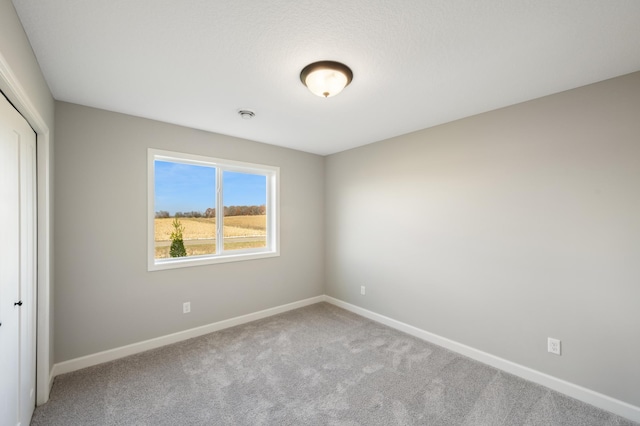 carpeted spare room with baseboards