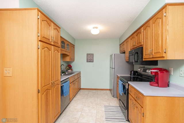 kitchen featuring stainless steel appliances, light countertops, brown cabinetry, glass insert cabinets, and a sink