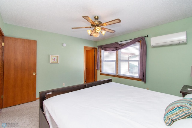 bedroom with light carpet, a textured ceiling, a wall unit AC, and a ceiling fan