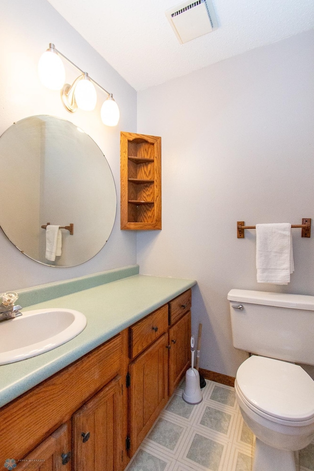 bathroom featuring toilet, vanity, visible vents, and tile patterned floors