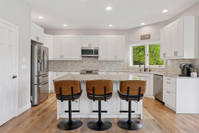 13380 Willandale Rd, Rogers, MN 55374 - kitchen featuring appliances with stainless steel finishes, a breakfast bar, a center island, a sink, and recessed lighting