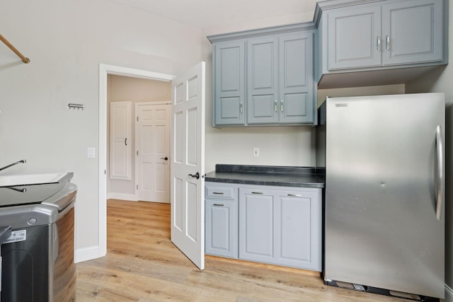 13380 Willandale Rd, Rogers, MN 55374 - kitchen with freestanding refrigerator, dark countertops, light wood-style flooring, gray cabinetry, and baseboards