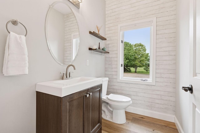 13380 Willandale Rd, Rogers, MN 55374 - bathroom featuring vanity, toilet, wood finished floors, baseboards, and wood walls