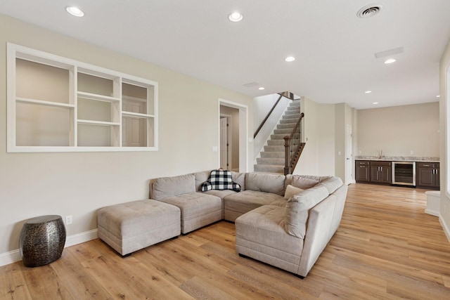 13380 Willandale Rd, Rogers, MN 55374 - living room with stairway, bar, beverage cooler, light wood-type flooring, and baseboards