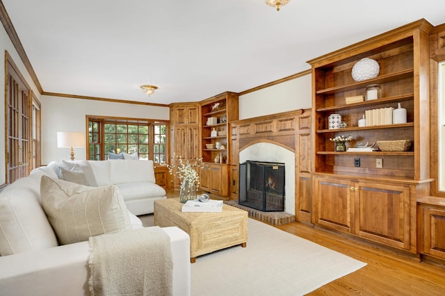 living room featuring light wood-style flooring, a fireplace, and ornamental molding