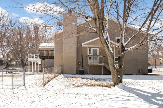 16860 Grenadier Ave, Lakeville, MN 55044 - snow covered house featuring a chimney, fence, and a trampoline