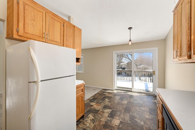 16860 Grenadier Ave, Lakeville, MN 55044 - kitchen featuring light countertops, baseboards, pendant lighting, freestanding refrigerator, and stone finish flooring