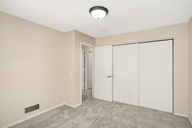 16860 Grenadier Ave, Lakeville, MN 55044 - unfurnished bedroom featuring baseboards, a closet, light colored carpet, and visible vents