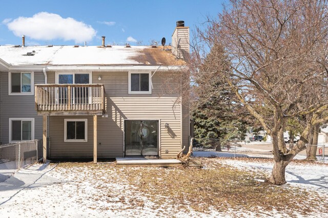 16860 Grenadier Ave, Lakeville, MN 55044 - snow covered back of property featuring a balcony, a chimney, and fence