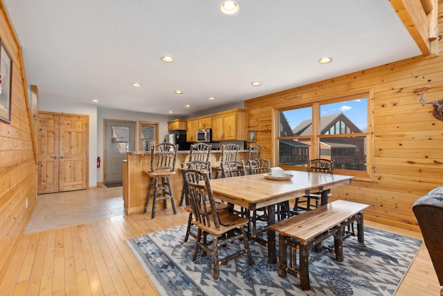 dining space featuring recessed lighting, wood walls, and light wood-style flooring