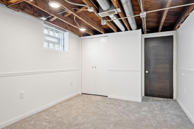 below grade area featuring visible vents, baseboards, and carpet flooring