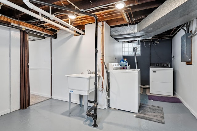 below grade area with electric panel, baseboards, and washing machine and dryer