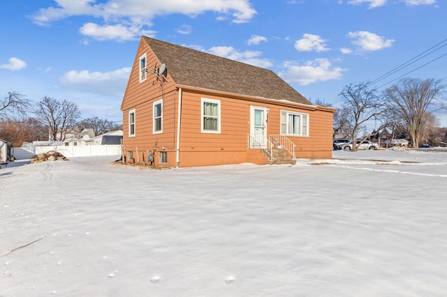 view of snow covered exterior with a shingled roof