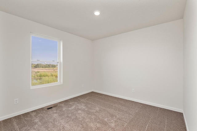 carpeted spare room with visible vents, baseboards, and recessed lighting