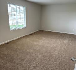 spare room with dark carpet and baseboards