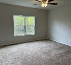 spare room featuring ceiling fan, baseboards, and carpet flooring