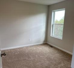 empty room featuring carpet flooring and baseboards