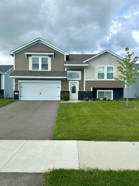 view of front of home featuring a front lawn, board and batten siding, an attached garage, and aphalt driveway