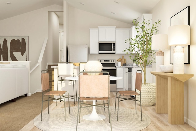 kitchen with white cabinetry, lofted ceiling, light wood-style floors, and stainless steel appliances