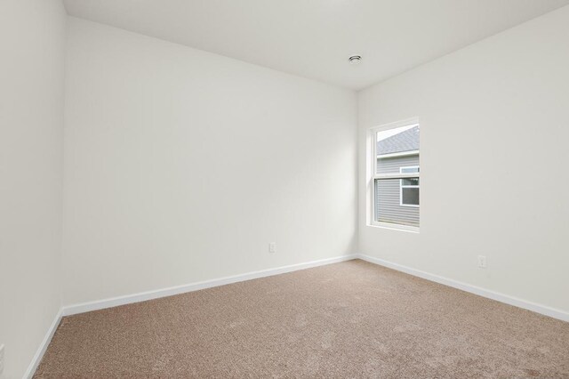 spare room featuring carpet and baseboards