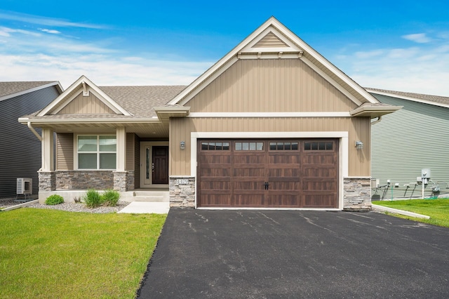 craftsman house featuring aphalt driveway, roof with shingles, a garage, stone siding, and a front lawn