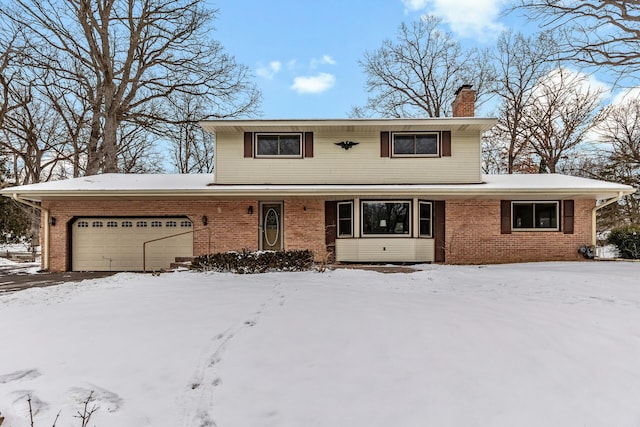 traditional-style home featuring brick siding, a chimney, and an attached garage