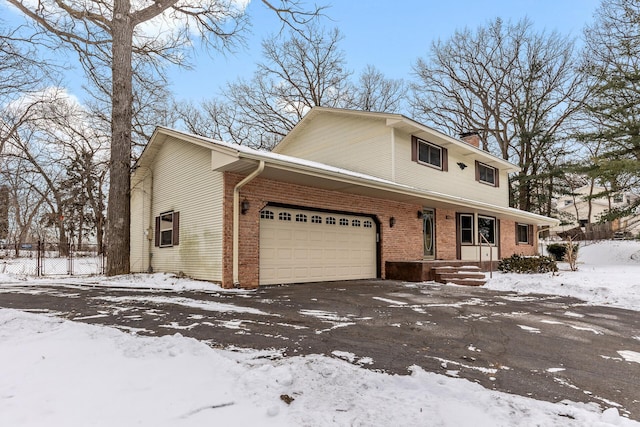 view of front of property featuring an attached garage, a chimney, and brick siding