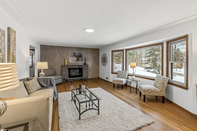 living room with a fireplace, baseboards, and wood finished floors