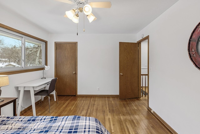 bedroom with ceiling fan, baseboards, and wood finished floors