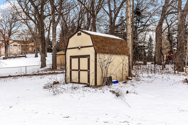 snow covered structure featuring fence