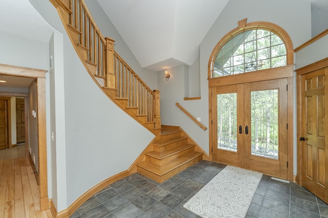 entryway with a wealth of natural light, french doors, baseboards, and stairs