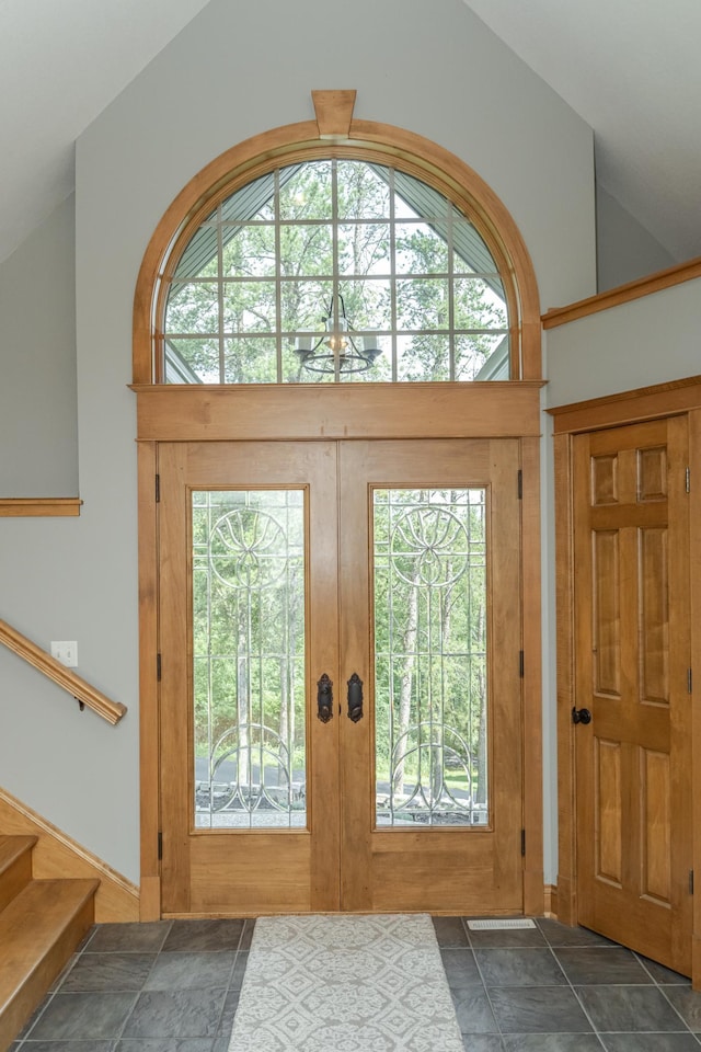 doorway to outside with high vaulted ceiling, french doors, and stairway