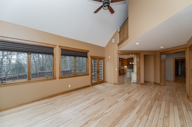 unfurnished living room with ceiling fan, high vaulted ceiling, baseboards, french doors, and light wood-type flooring