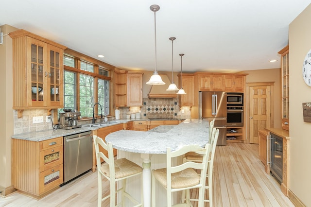 kitchen featuring beverage cooler, appliances with stainless steel finishes, backsplash, and a sink