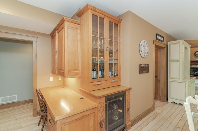 bar featuring light wood finished floors, baseboards, visible vents, wine cooler, and a bar