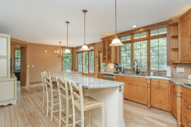 kitchen featuring light wood finished floors, tasteful backsplash, and a sink