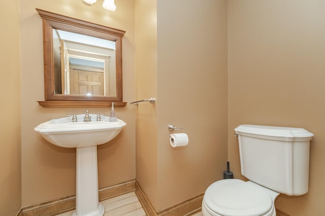 half bath with toilet and baseboards